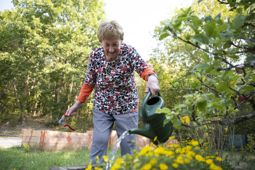 Une résidente arrose les fleurs