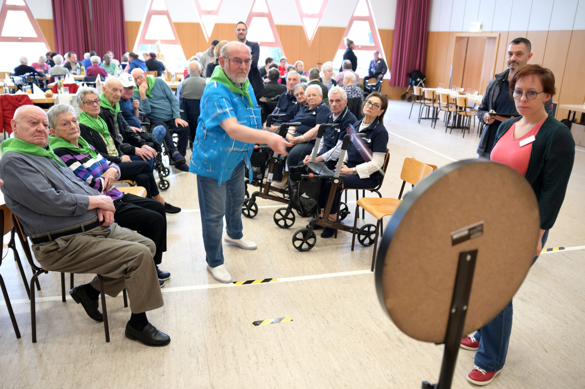 Alter Herr wirft Darts bei einem Wettbewerb