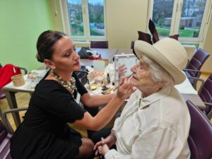 Une dame maquille une aînée