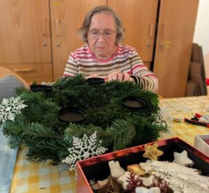 Une dame confectionne une décoration de Noël