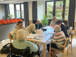 Des jeunes et des aînés discutent à table